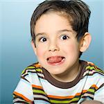 Portrait of little boy sticking out tongue