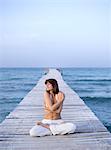 Woman sitting cross-legged on pontoon