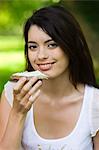 Young woman eating slice of bread with cheese