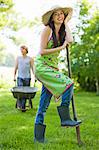 Young woman with foot on a spade