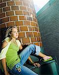 Teenage girl sitting on building roof