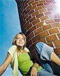 Teenage girl sitting on building roof