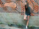 Teenage girl leaning against wall