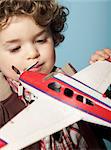 Little boy playing with toy airplane