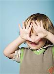 Little boy with hands covering face