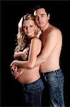 Man embracing topless pregnant woman