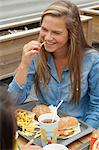 Teenage girl wearing a dental brace, eating an hamburger with french fries