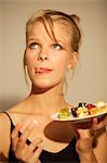 Portrait of a young woman eating petits fours