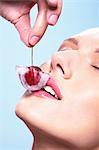 Portrait of a young woman holding a cherry in an ice-cube