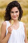 Portrait of young woman holding cereal bar