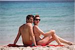 Young couple relaxing at the beach during summer holidays, Cala Cipolla, Chia Bay, Sardinia, Italy