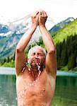 Close-up of Mature man standing in lake, splashing water on face, Lake Vilsalpsee, Tannheim Valley, Austria