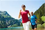 Mature man and woman power walking, Lake Vilsalpsee, Tannheim Valley, Austria