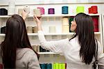 Women choosing spool of thread in store