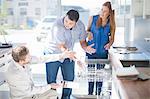 Couple and salesman looking at dishwasher in kitchen showroom