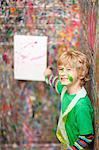 Boy pointing to painting on paint-splattered wall