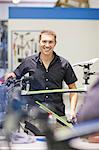 Mid adult man in repair shop with bicycle