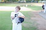 Portrait of boy wearing cricket gloves and holding helmet