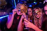 Young woman wearing mask in limousine