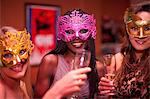 Young women wearing masquerade masks at hen party