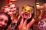 Young woman wearing masquerade mask at hen party