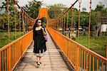Woman on bridge over river, Vang Vieng, Laos