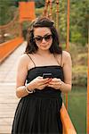 Woman using smartphone on bridge