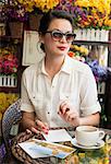 Woman with postcards in cafe