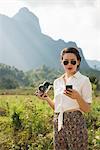 Woman using smartphone, Vang Vieng, Laos