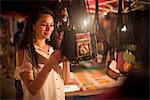 Woman looking at handbags in night market, Luang Prabang, Laos