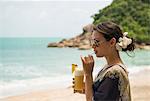 Woman drinking on beach, Banyon Tree Resort, Ko Samui, Thailand