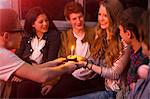 Group of teenagers sitting around birthday cake