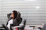 Woman sitting in office chair in front of large wall calendar
