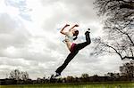 Woman jumping in mid air with bent leg