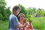 Mother and son looking at stem of leaves