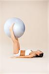 Woman doing hard exercises with rubber fitness ball