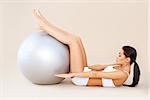 Cute woman doing abdominal muscles with fitness ball