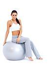 Athletic woman relaxing on fitness ball  while isolated on white background