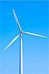Wind turbine set against a blue sky