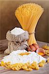Pasta with ingredients - flour and eggs on old wooden table