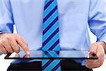 Businessman working on tablet computer - closeup on device and hands, copyspace