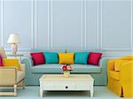 Beautiful composition of blue sofa and bright chairs with colorful pillows