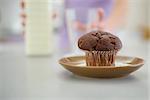 Closeup on chocolate muffin and teenager girl with milk in background