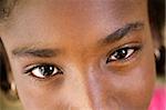 Closeup of eyes of pretty happy young african girl looking at camera and smiling