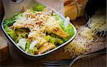 fresh caesar salad on bowl with parmesan cheese