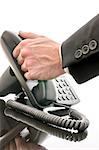 Cropped view of a male hand answering a phone on a black office table.