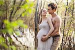 Young pregnant couple at the river in spring