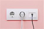 Electric and internet outlets on pink wall, electric cable and internet
