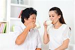 Drinking milk. Happy Asian family drinking milk at home. Beautiful senior mother and adult daughter, healthcare concept.