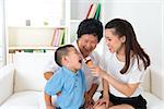 Eating ice cream. Happy Asian family at home, grandparent, parent and grandchild sharing an ice cream. Home indoor with decoration.